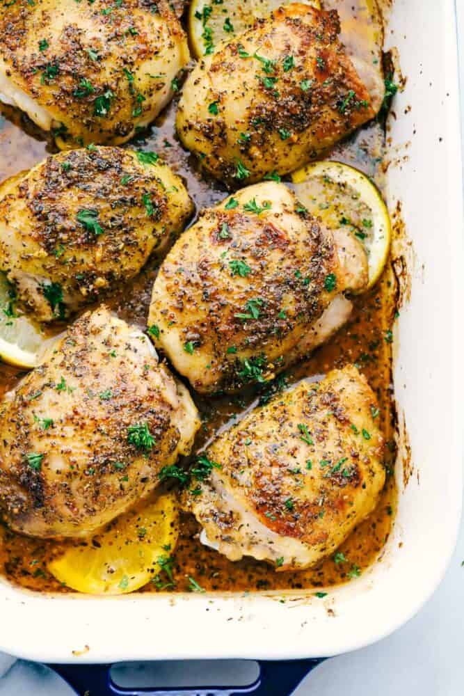 Baked chicken thighs in a white pan.