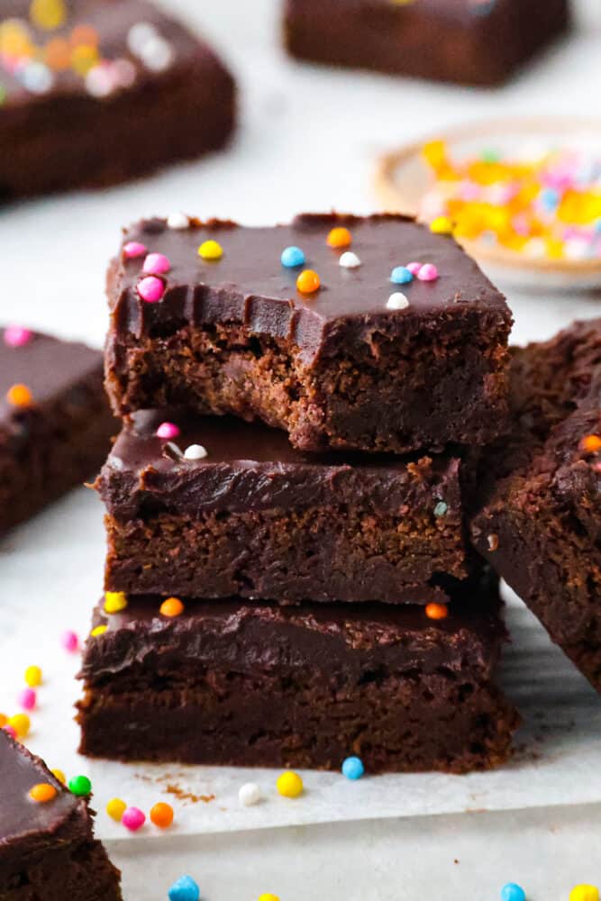 3 brownies stacked on top of each other. One has a bite taken out of it.