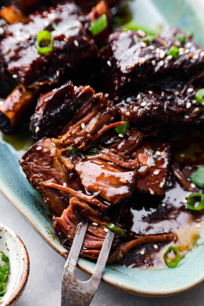 A close up on the Korean short ribs on the platter being pulled apart.