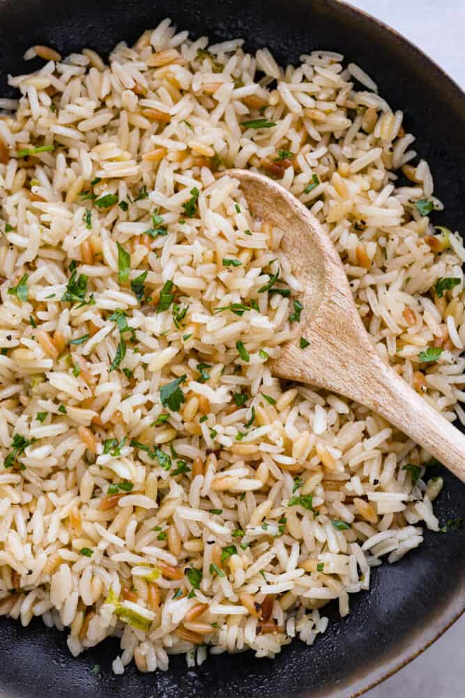 Closeup of pilaf in a black bowl.