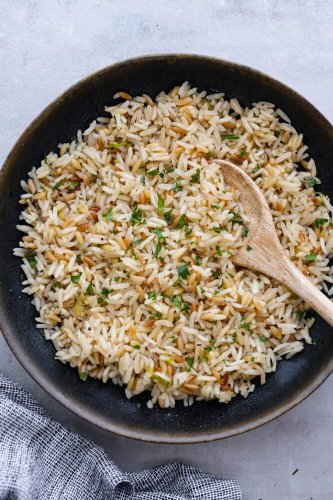 Top-down view of rice pilaf served in a black bowl.