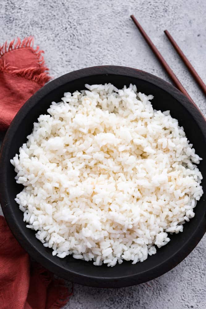 Sushi rice in a black bowl.