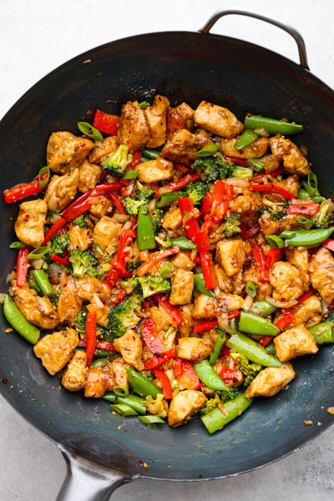 Top-down view of Szechuan chicken in a wok.