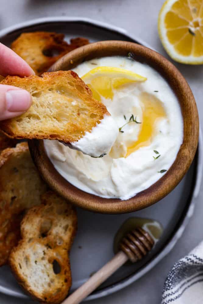 Dipping a slice of baguette in the whipped ricotta.