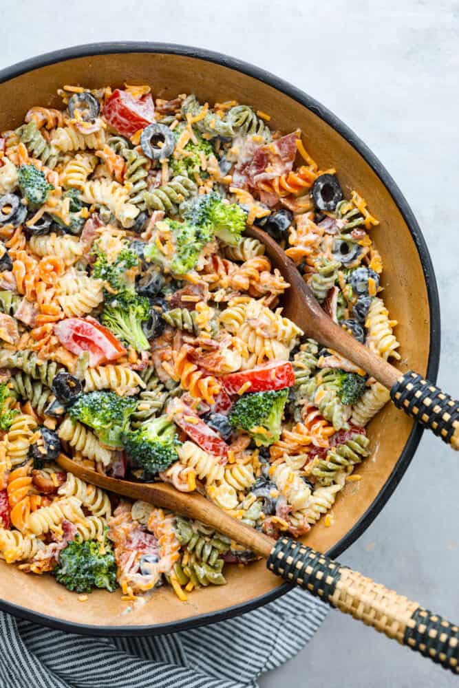 A bowl of ready to eat bacon ranch pasta sale with 2 wooded spoons in the bowl. 