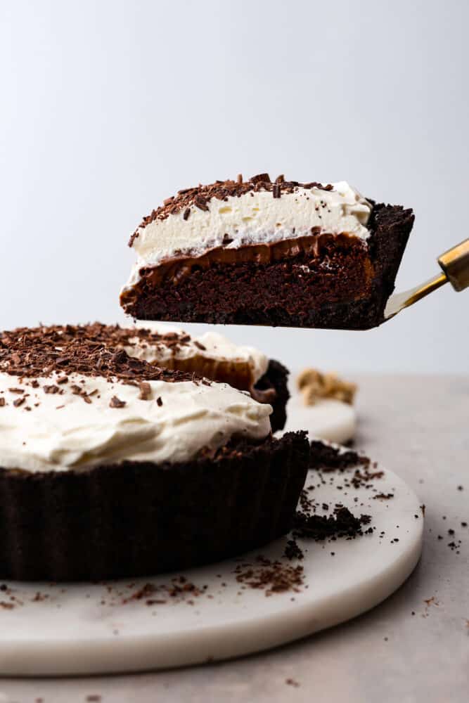 A slice of Mississippi mud pie being taken out with a gold server. 