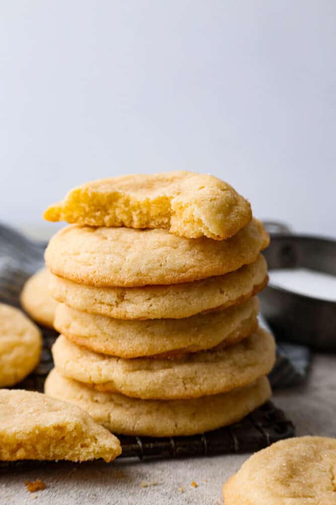 Overhead view of soft sugar cookies stacked on a cooling rack. 