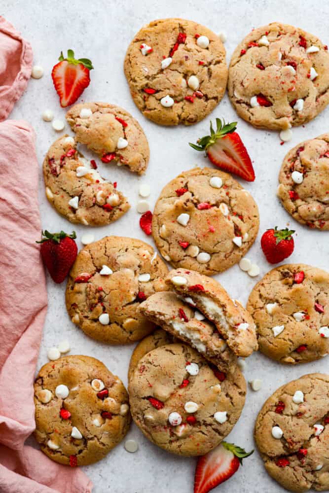 Top-down view of strawberry cheesecake cookies, with some of them broken in half.