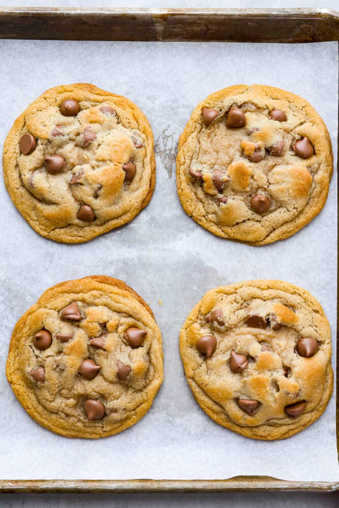 Top view of baked copycat Crumbl cookies on a cookie sheet lined with parchment paper.