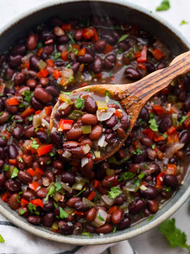 Closeup of beans in a wooden spoon.