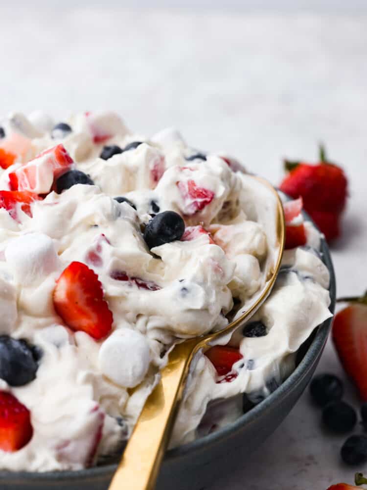 Cheesecake salad being scooped up with a gold spoon.