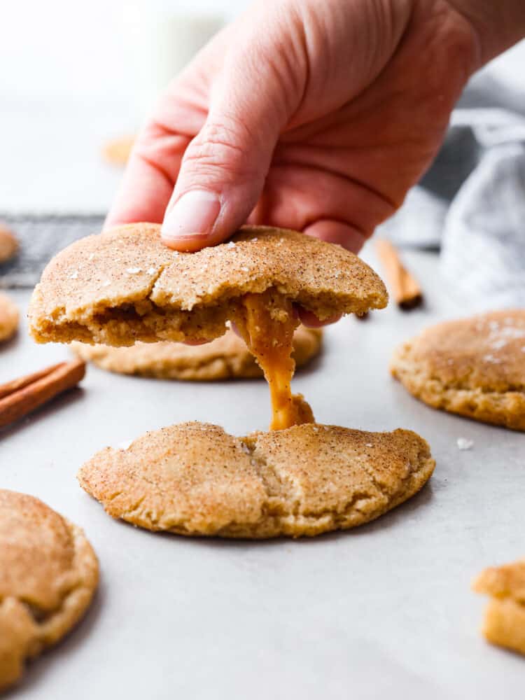 Picking up half of a cookie.