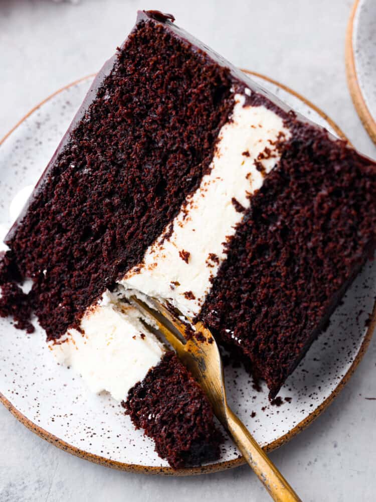 Taking a bite of cake with a golden fork.