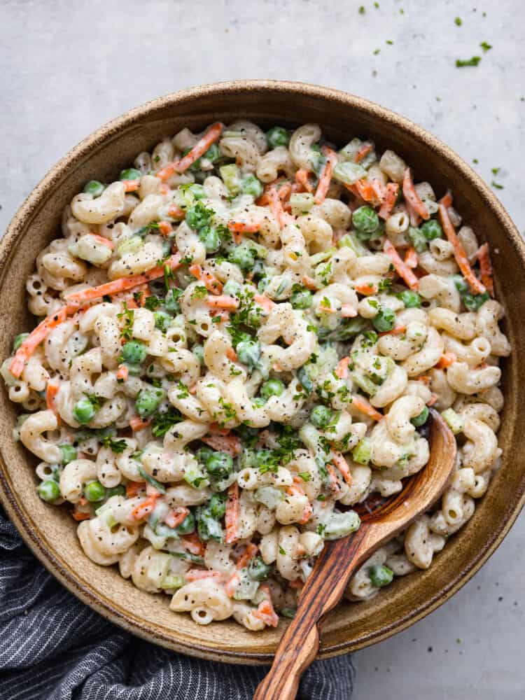 Top-down view of macaroni salad in a wooden bowl.