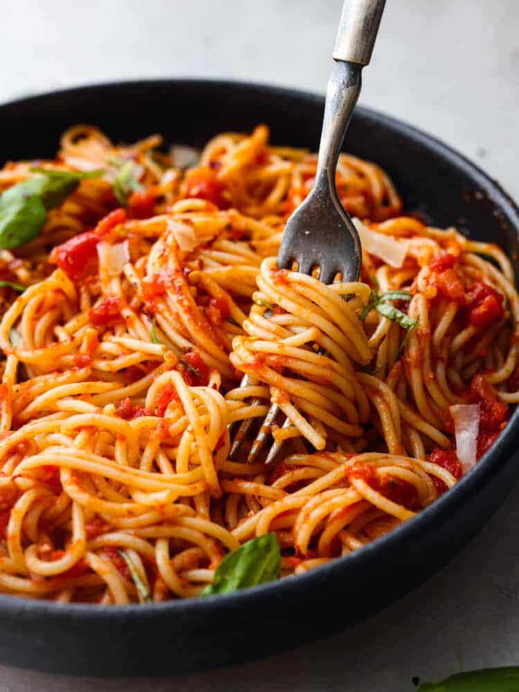 A close up of pasta wrapped around.a fork in a bowl. 