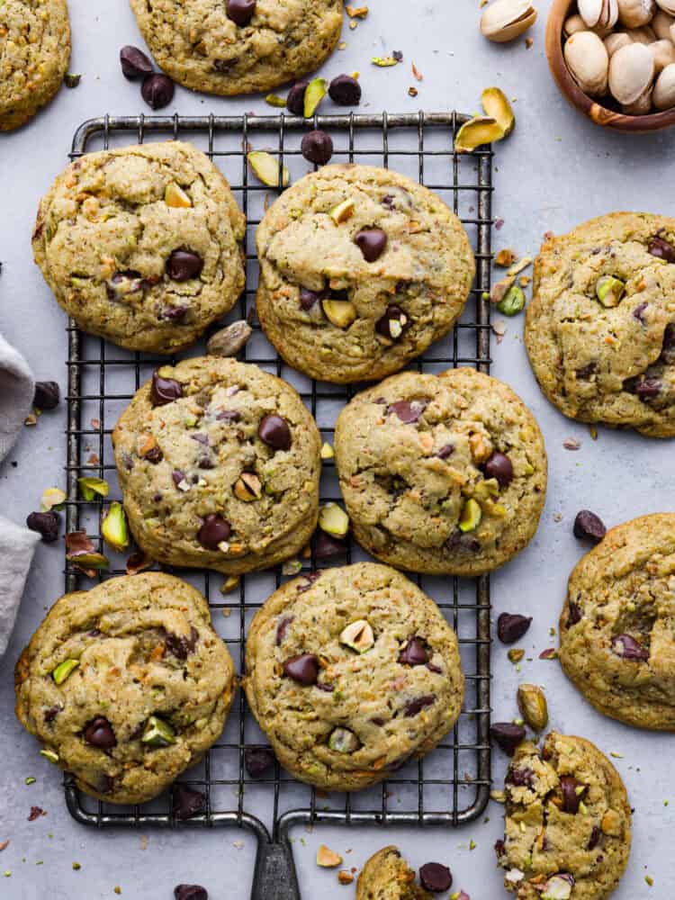 Top-down view of pistachio cookies on a cooling rack.