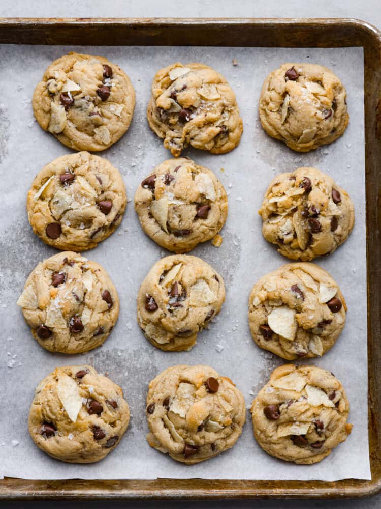 Overhead view of potato chip cookies baked on a sheet pan lined with parchment paper. 