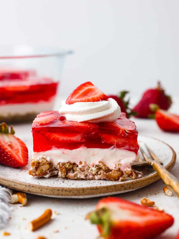 A slice of strawberry pretzel salad on a stoneware plate.