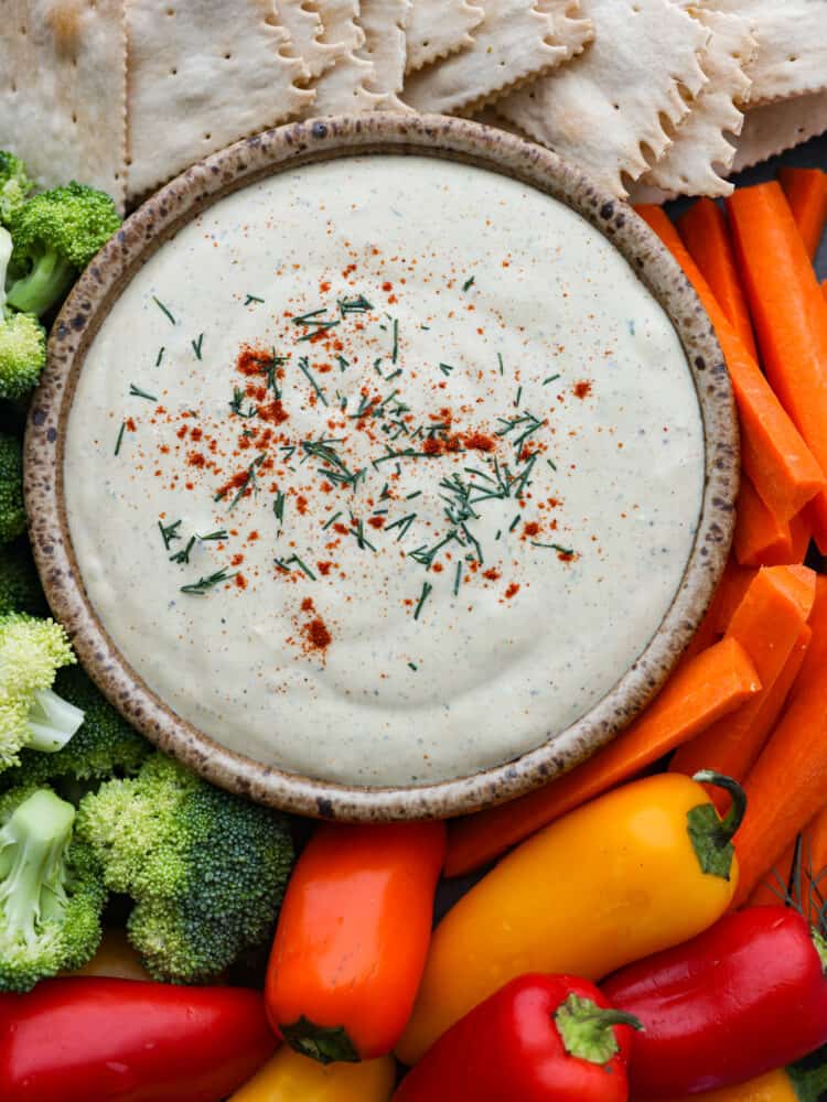 Top-down view of cottage cheese dip, surrounded by crackers and veggies.