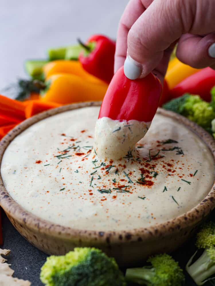 A pepper being dipped into the cottage cheese mixture.