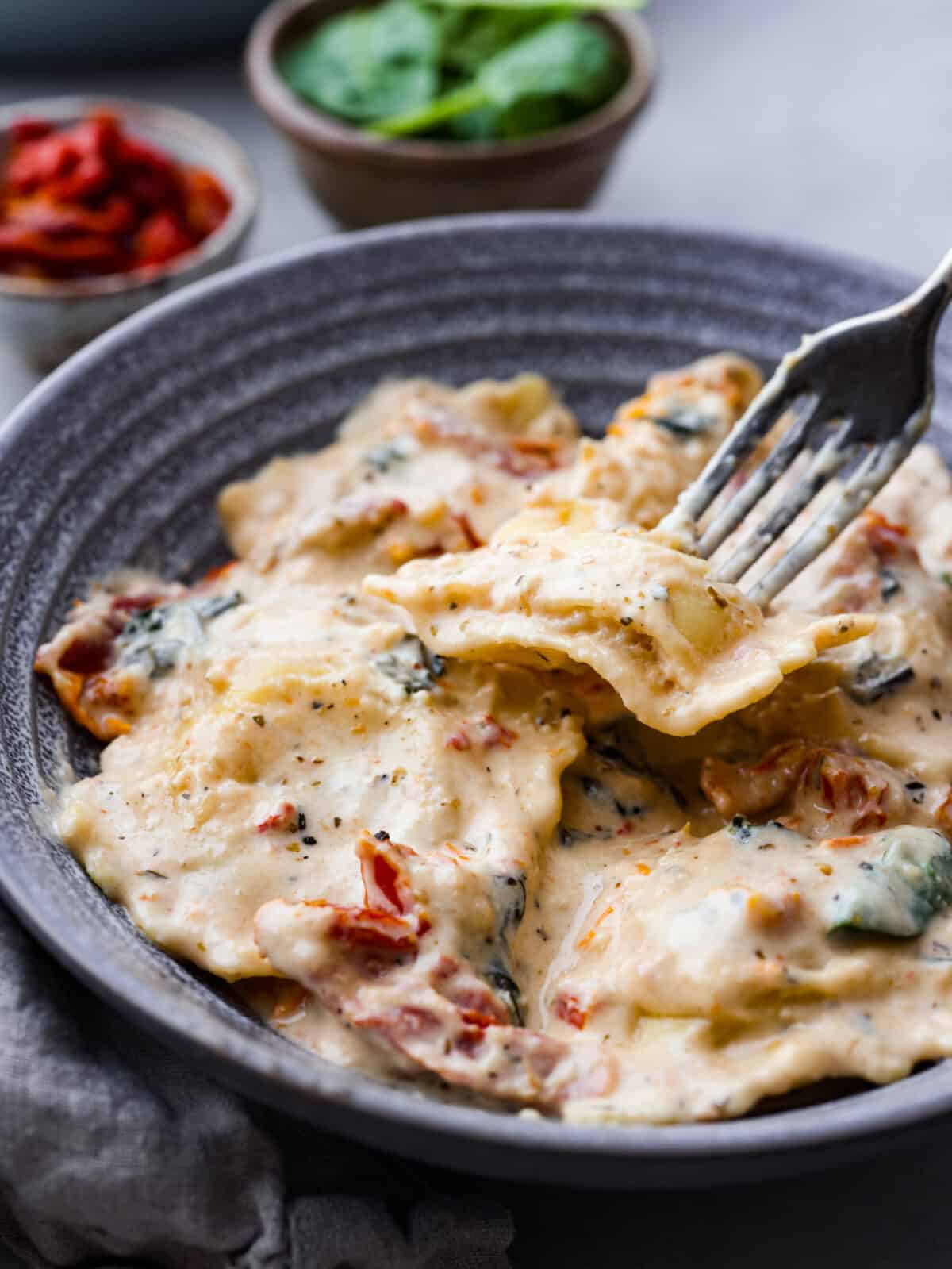 Closeup of ravioli served in a gray stoneware bowl.