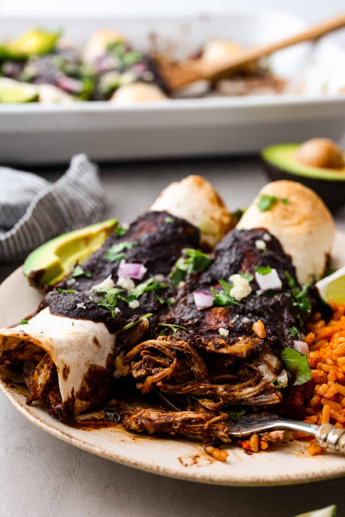 2 burritos on a stoneware plate. The chicken filling can be seen.