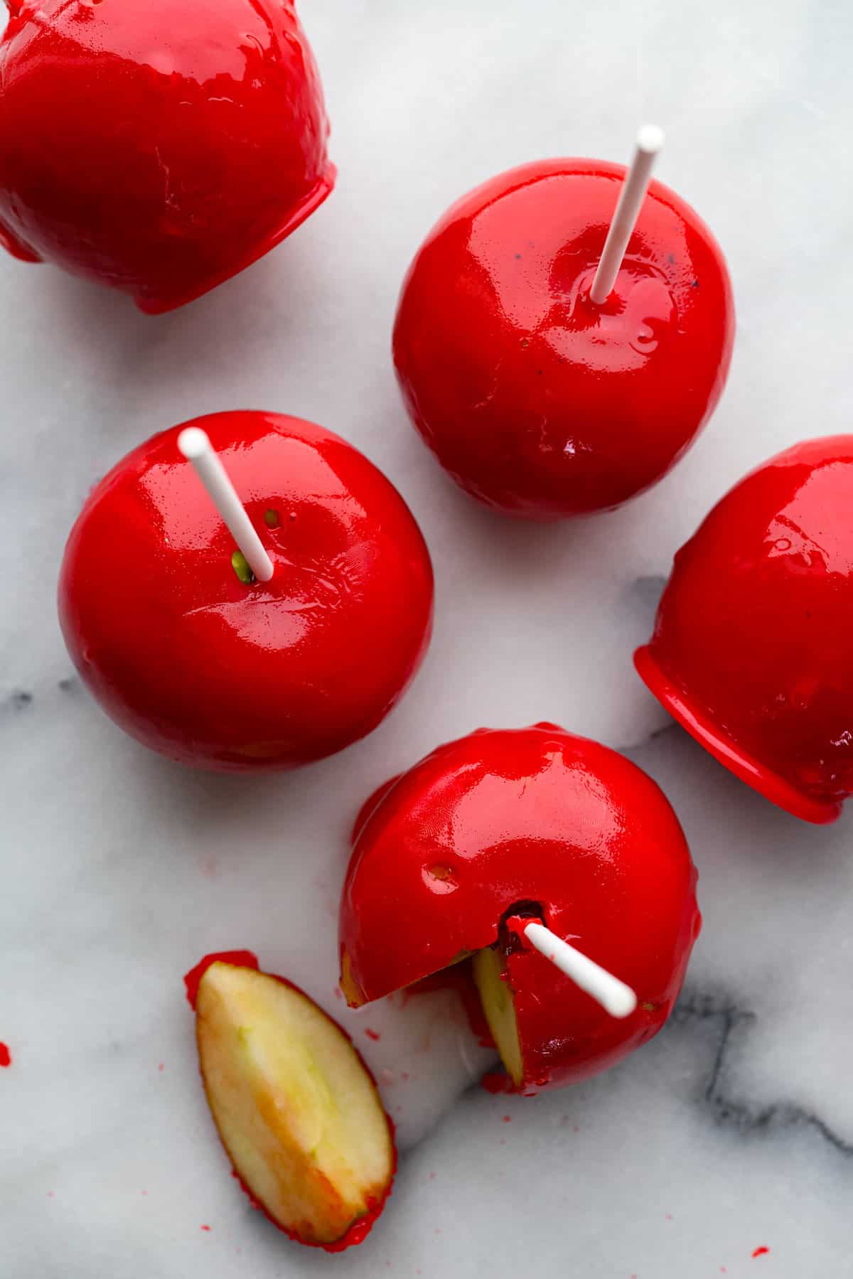 Top-down view of candy apples. One has a piece cut out of it.