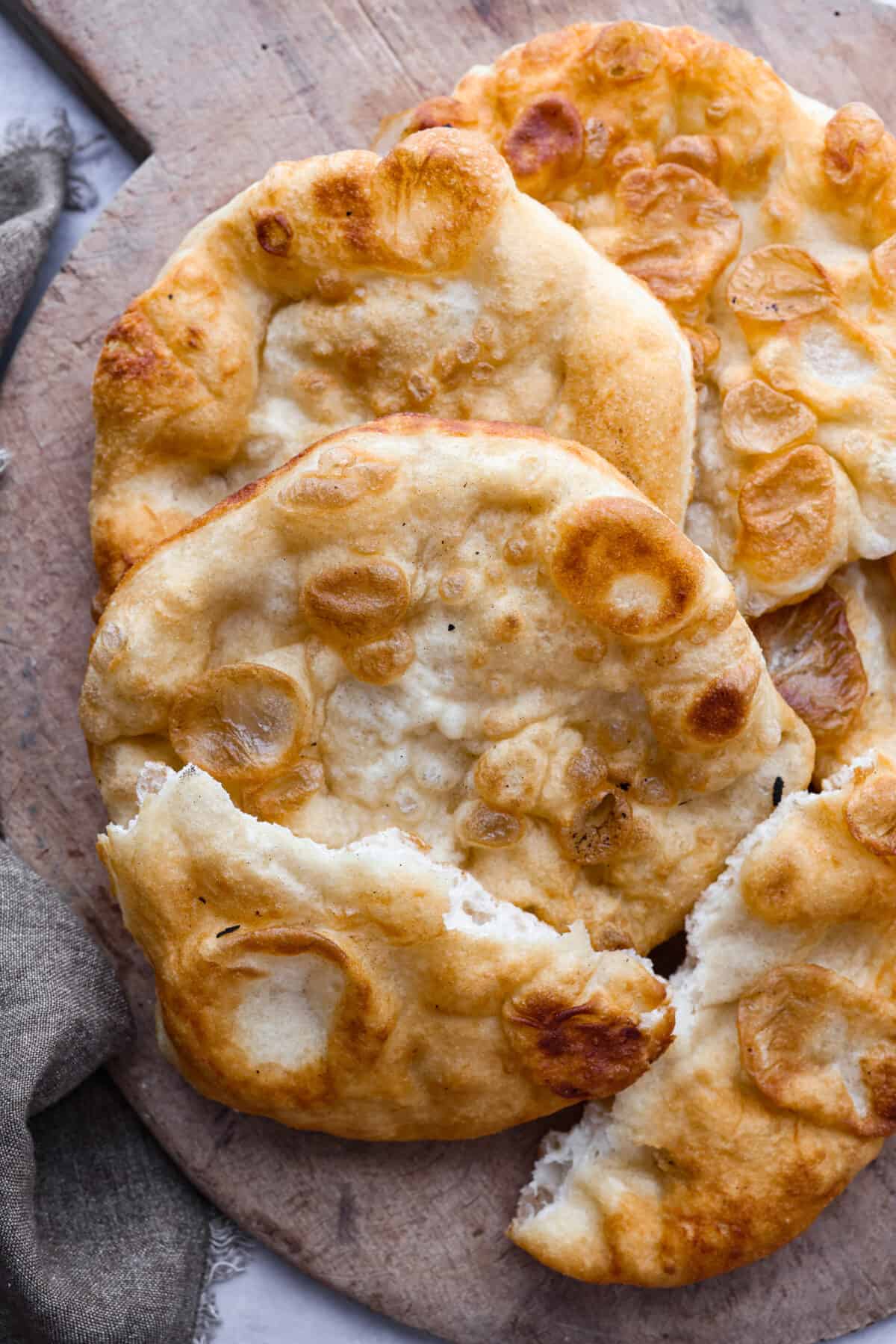 Top-down view of fry bread with one piece torn in half.