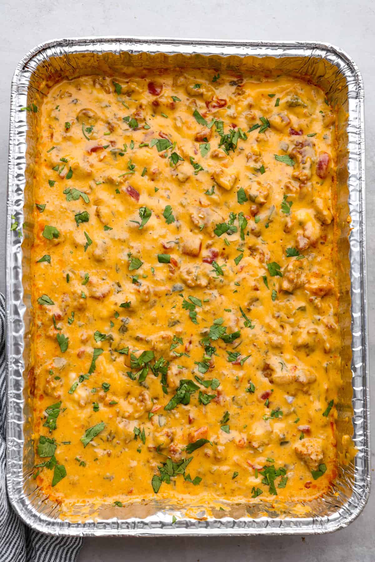 Top view of smoked queso dip in a disposable aluminum pan.