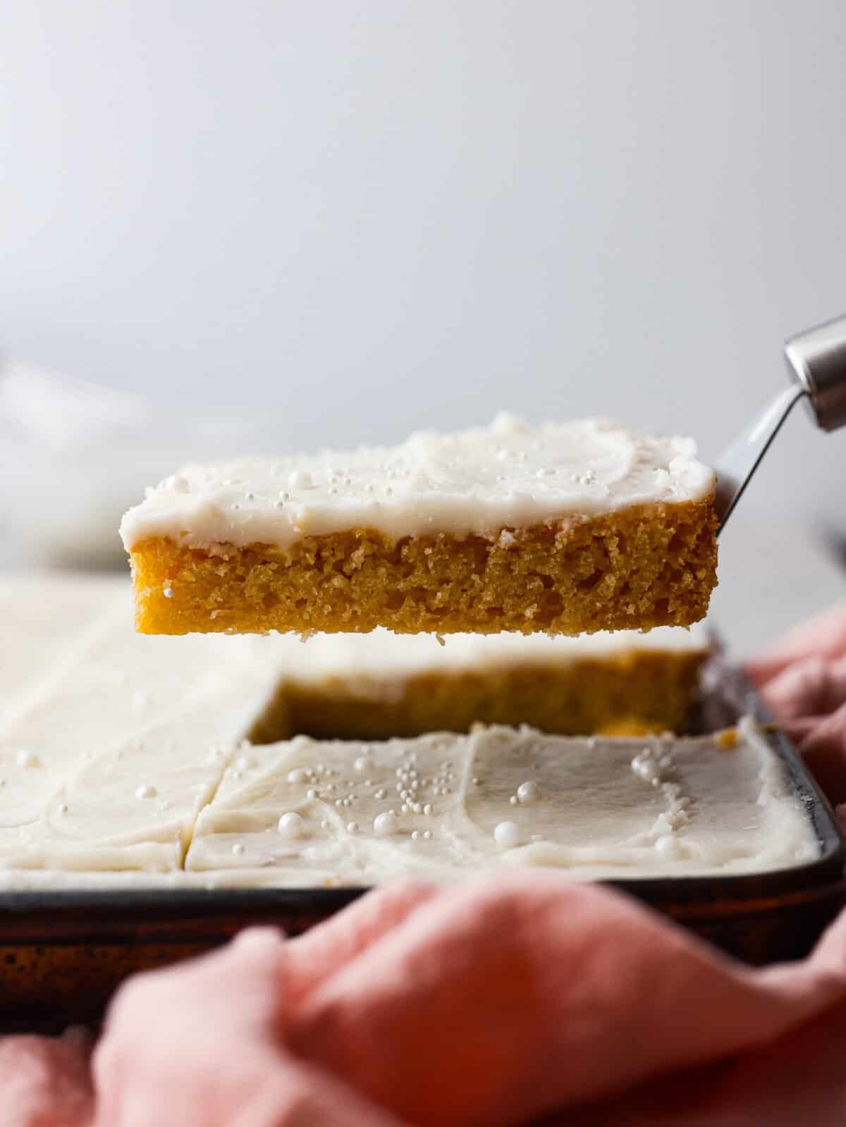 Serving a slice of white Texas sheet cake.