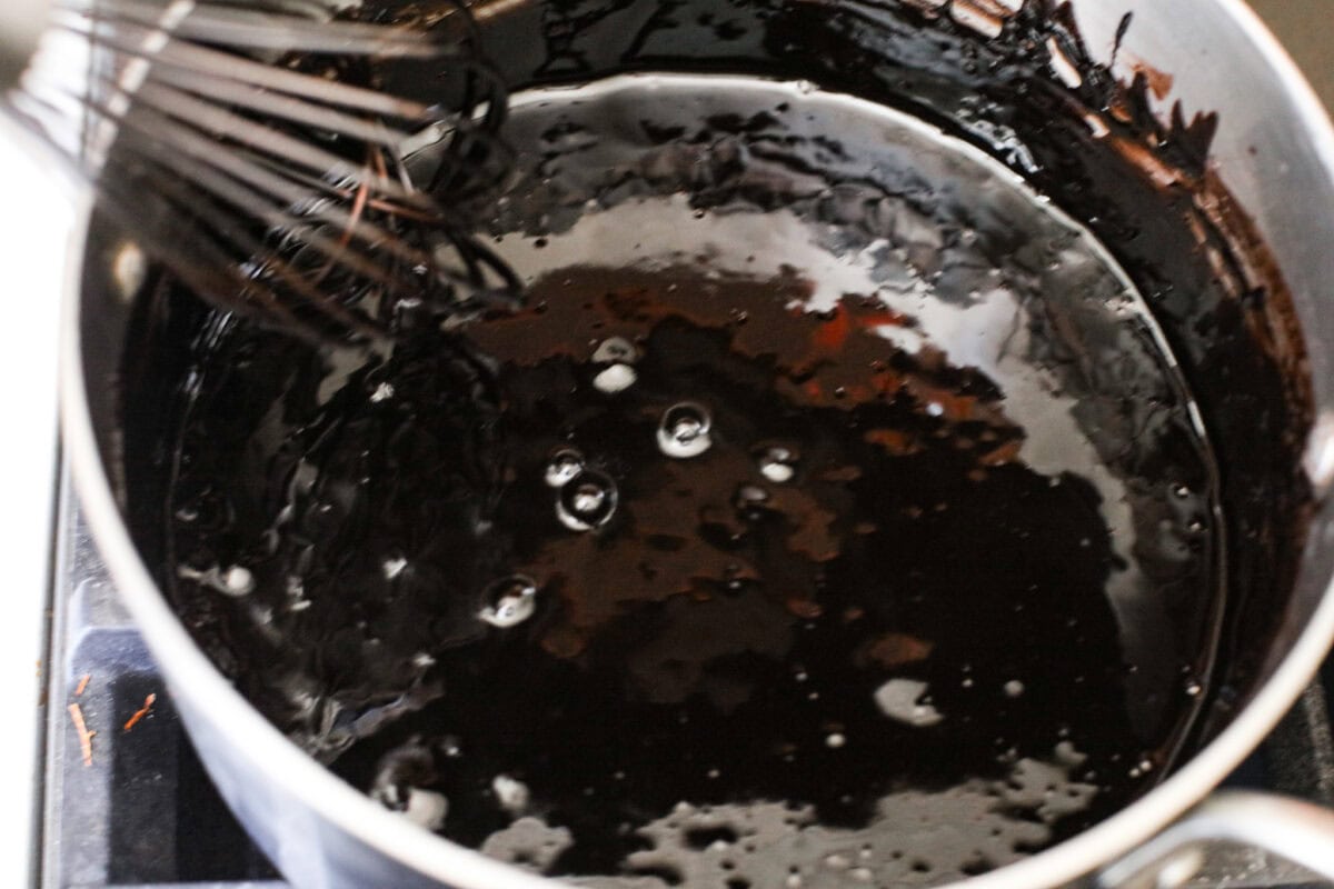 Overhead shot of the milk and sugar mixture in a pan, cooking on the stove top. 