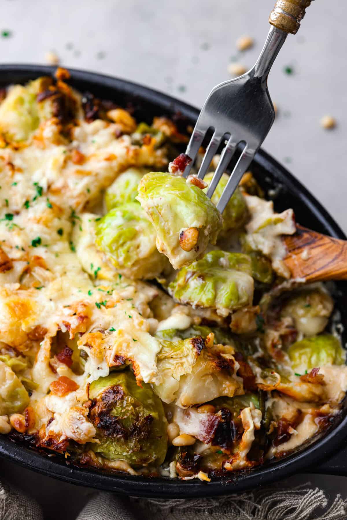 Picking up a brussels sprout with a metal fork.