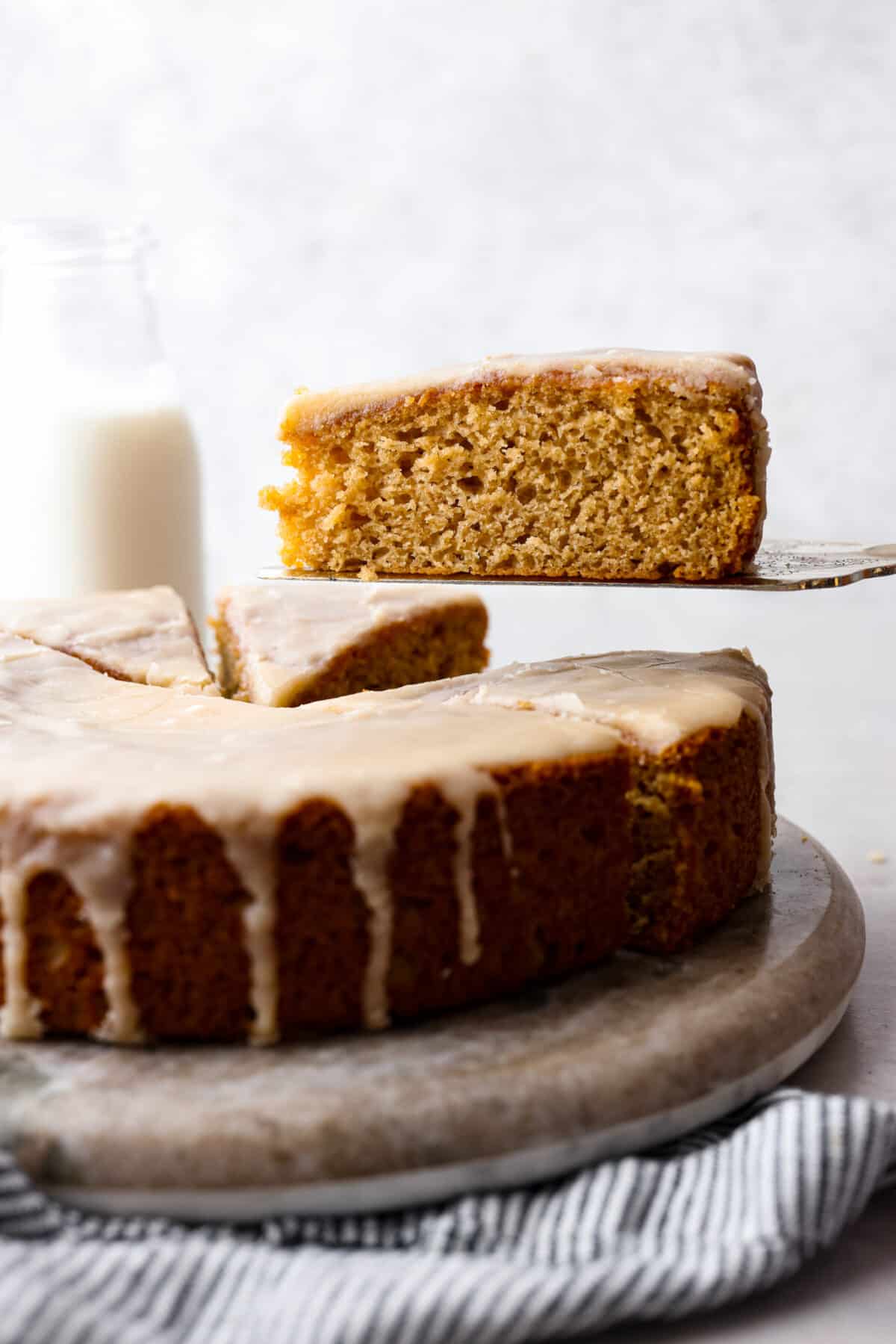 A slice of buttermilk cake being served with a metal spatula.