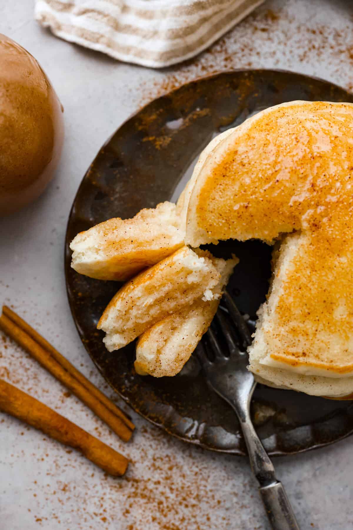 Overhead shot of plated pancakes with a bit taken out.