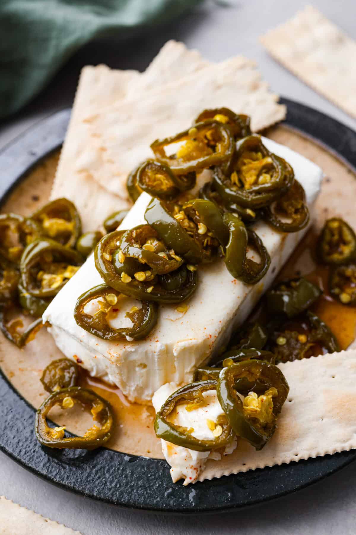 A block of cheese topped with cowboy candy, served with crackers.