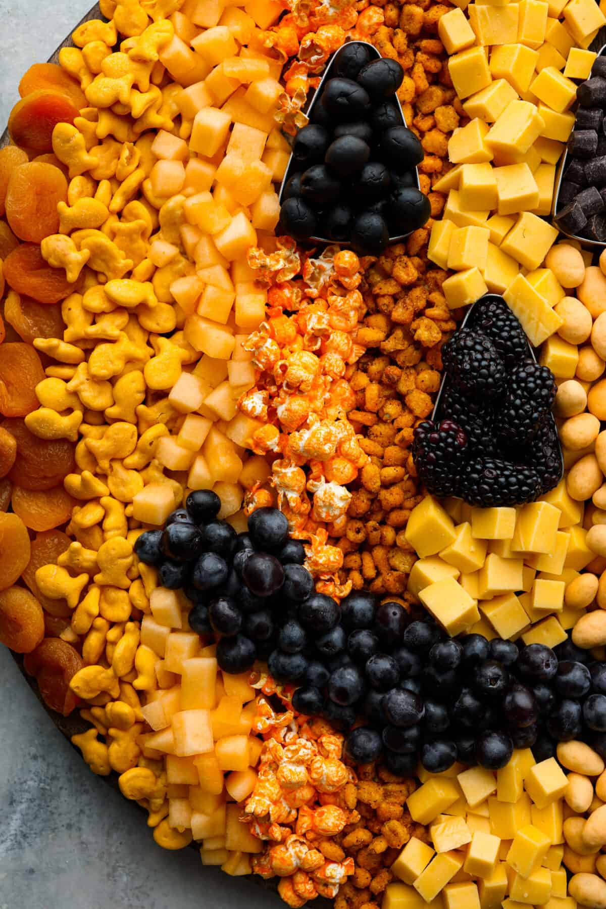 Close view of fruit, crackers, and popcorn on the pumpkin charcuterie board.