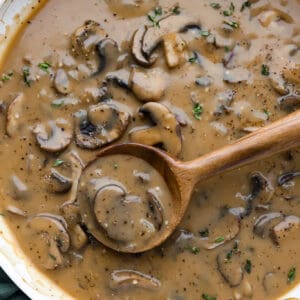 Mushroom gravy cooking in a large skillet.