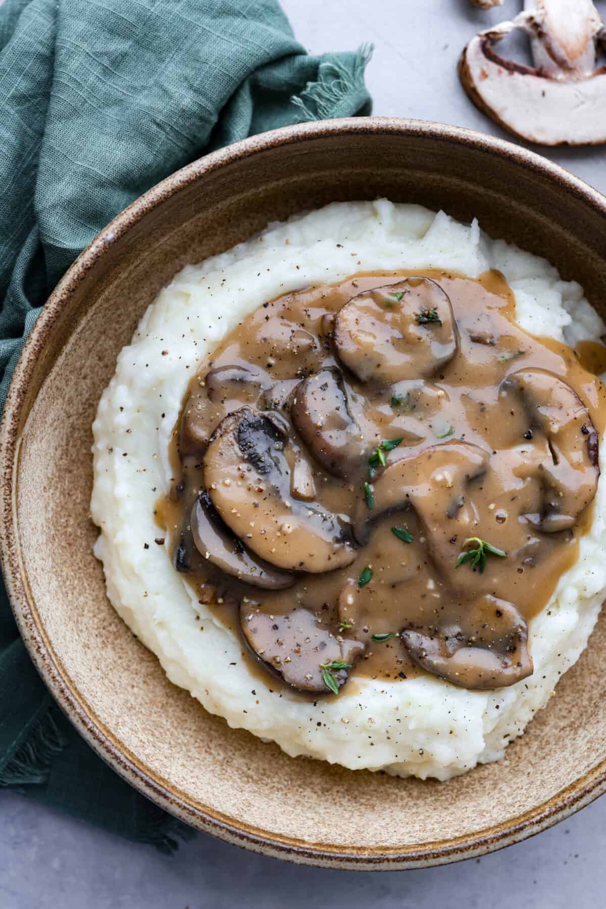 Top-down view of mashed potatoes served in a brown bowl.