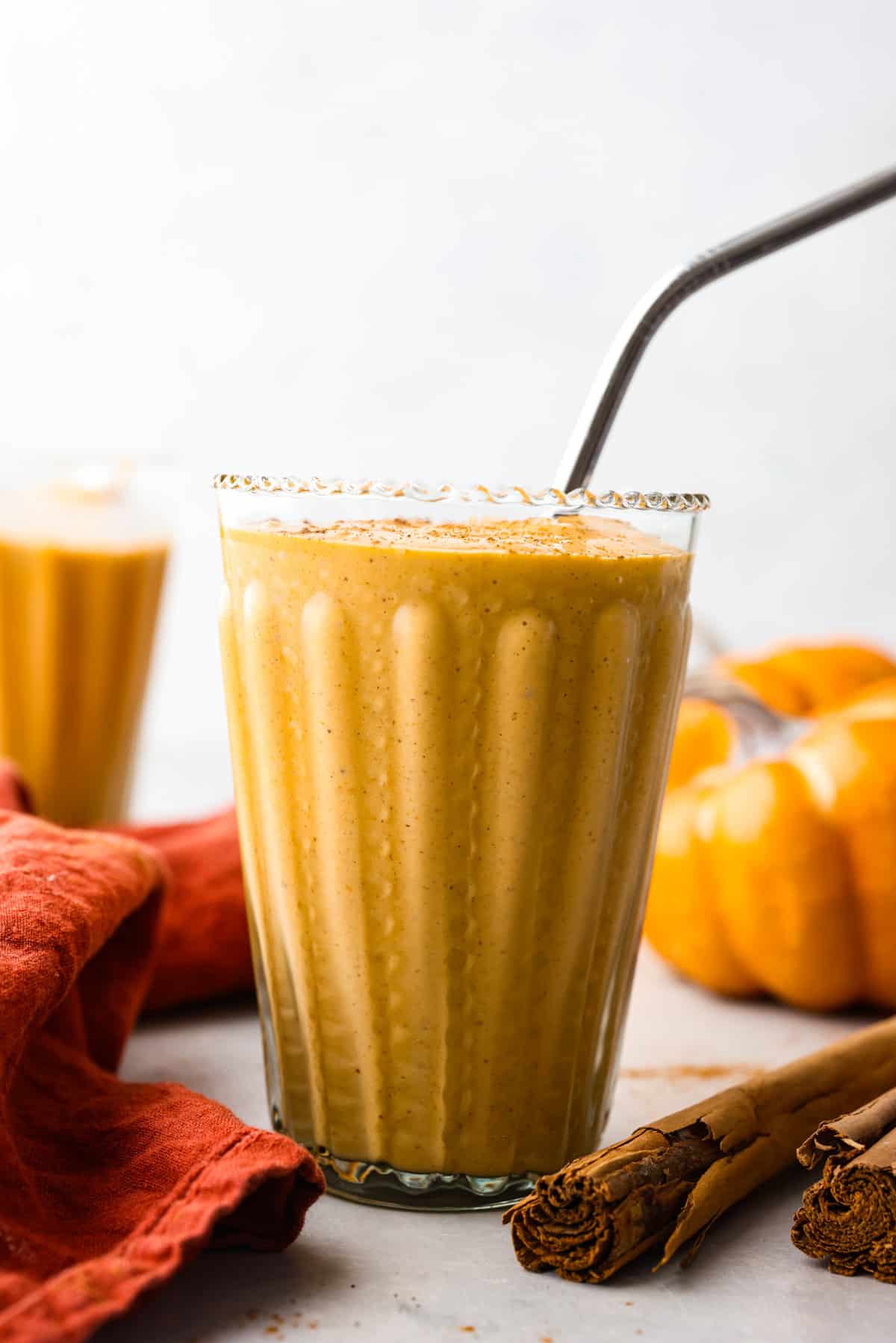 A pumpkin smoothie served in a glass cup.