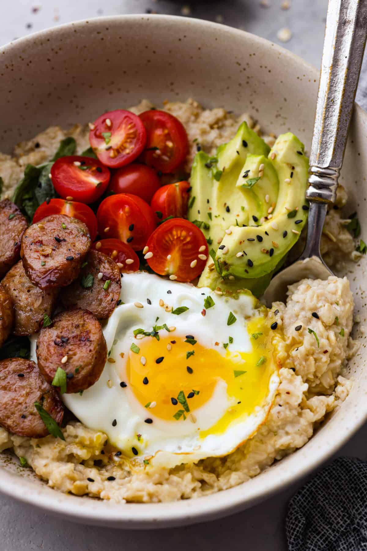 A bowl of oatmeal with a spoon scooping some out. 