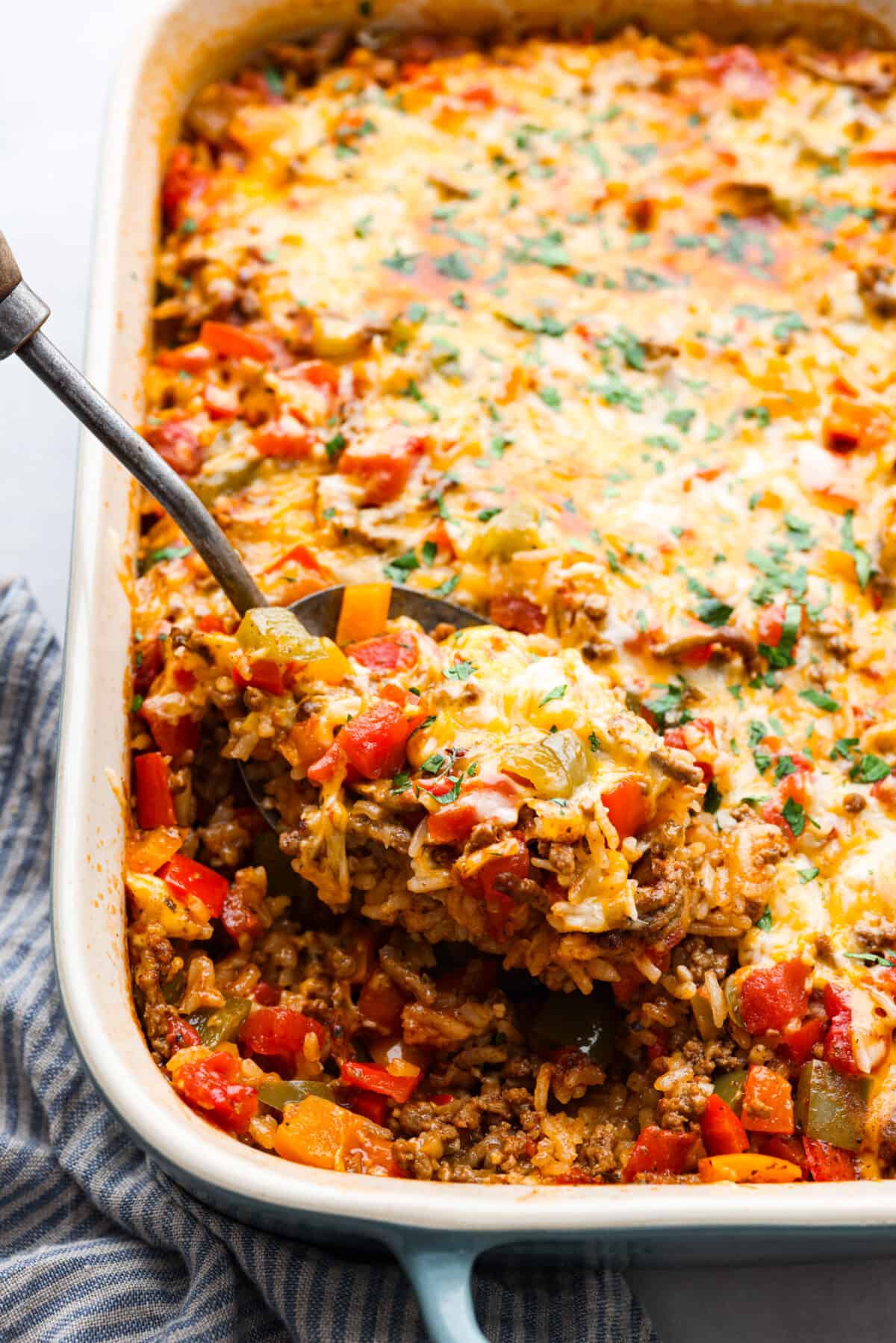 Closeup of stuffed pepper casserole on a metal serving spoon.