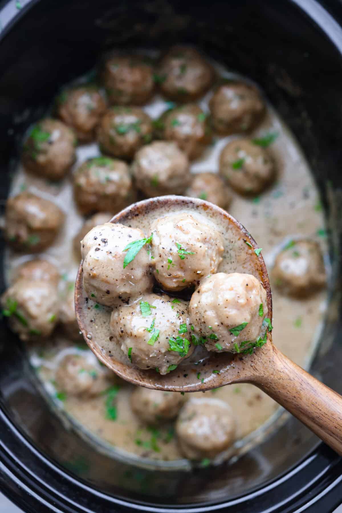 Close up shot of a scoop of slow cooker Swedish meatballs.