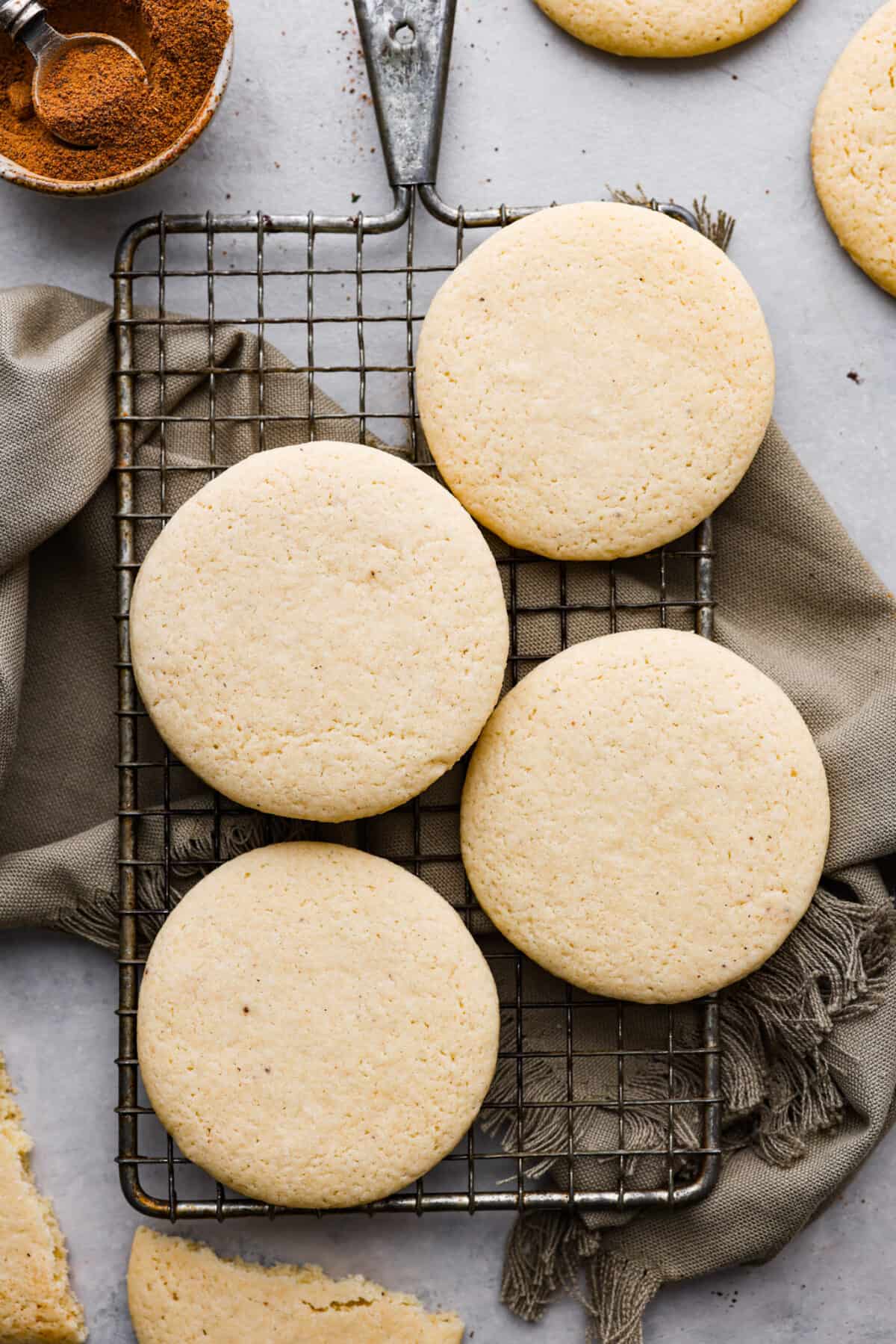 Overhead shot of tea cakes on a cooling rack over a tea towel. 