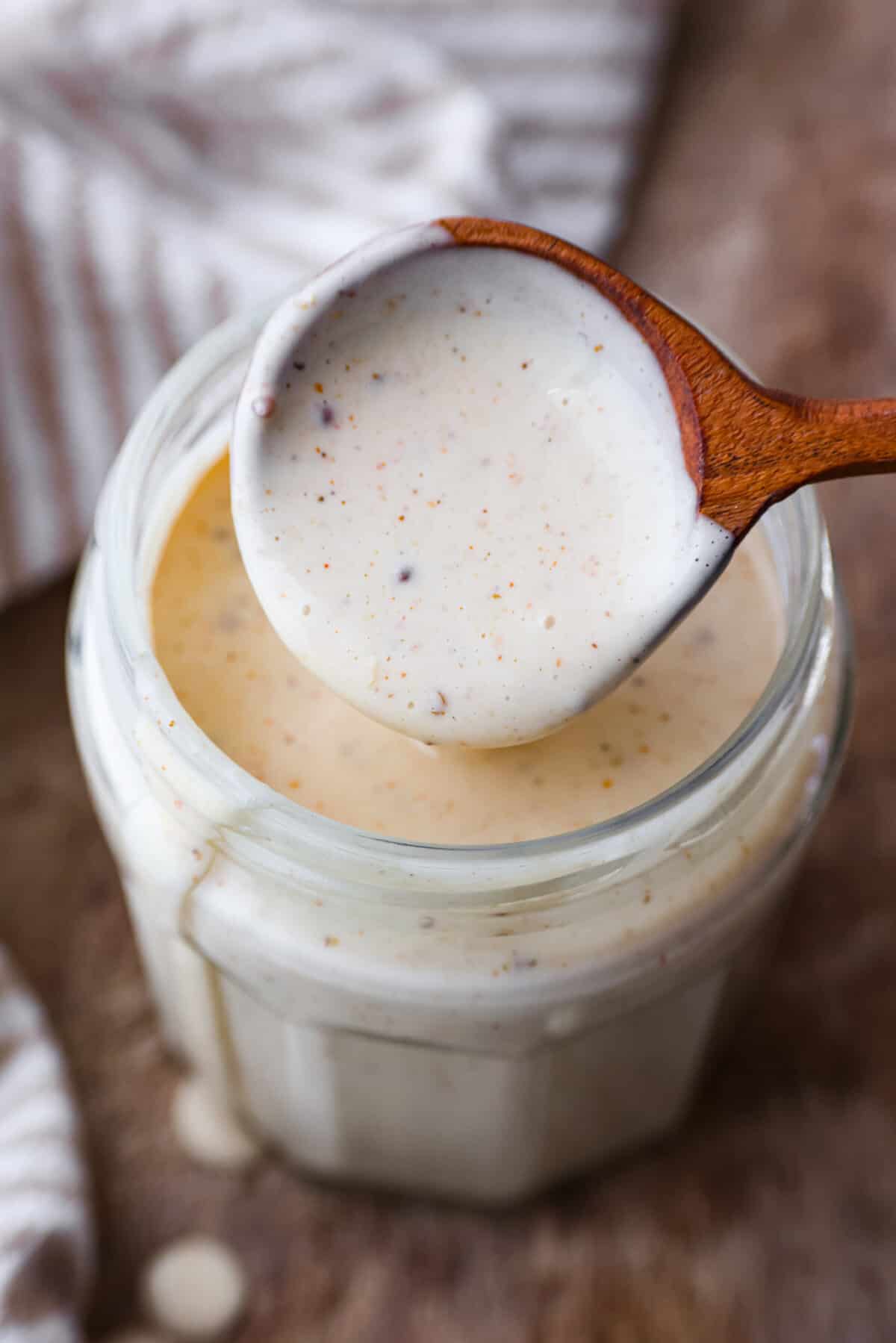 A close up of Alabama White BBQ Sauce on a wooden spoon. 