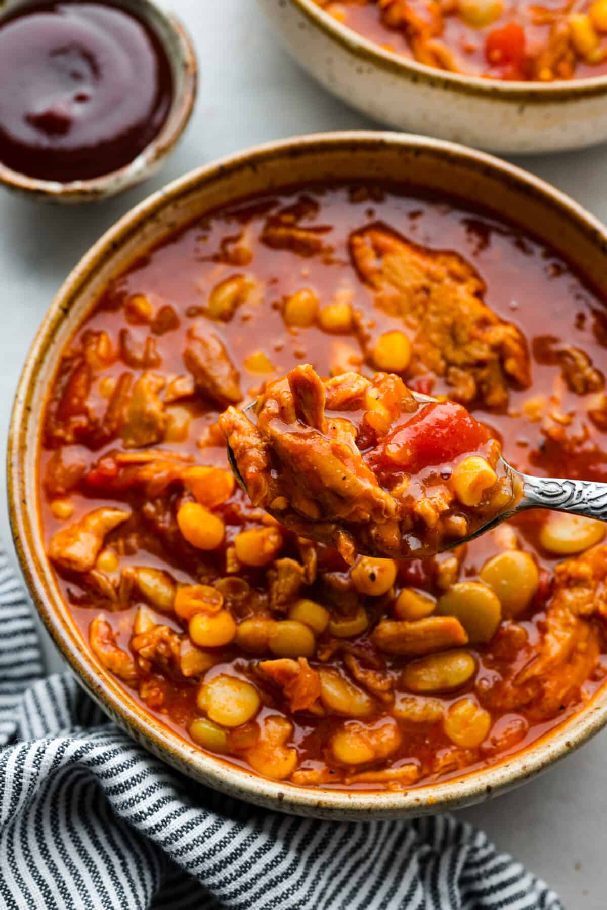 An individual serving of the soup made of bbq sauce, pulled pork, corn, and fire-roasted tomatoes.