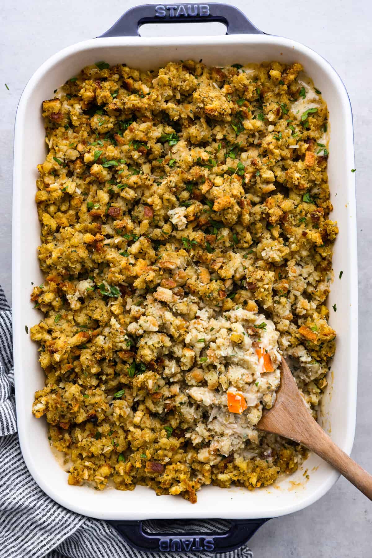 Top-down view of baked chicken and stuffing casserole in a blue and white staub pan.