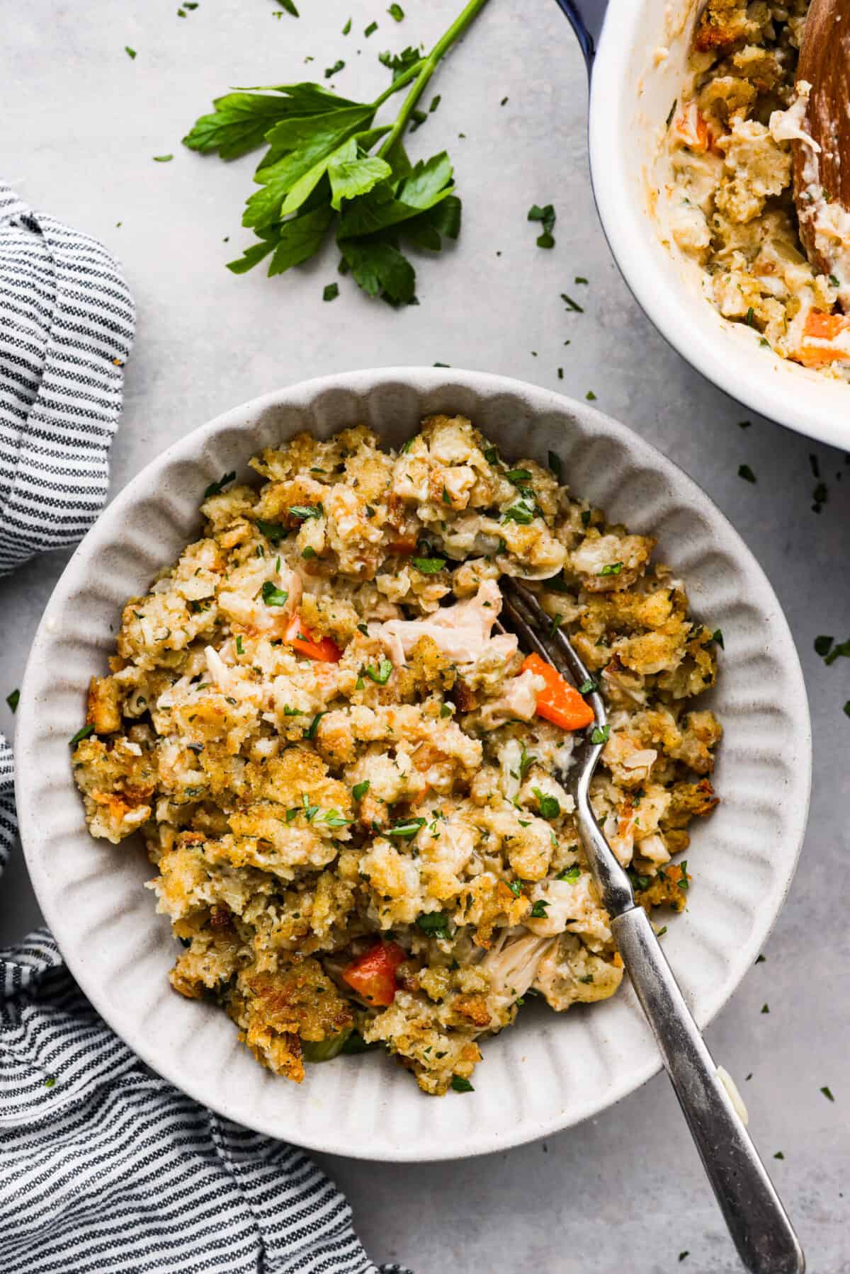 A serving of casserole in a white scalloped bowl.