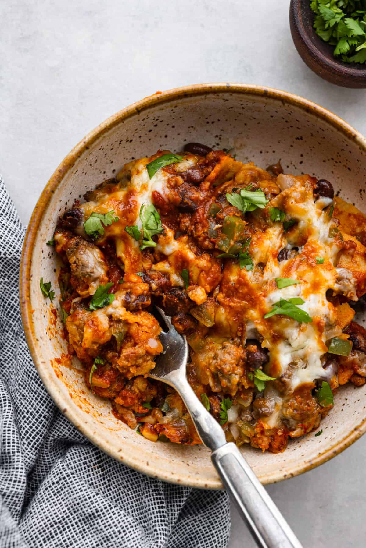 A serving of enchilada pie in a stoneware bowl.