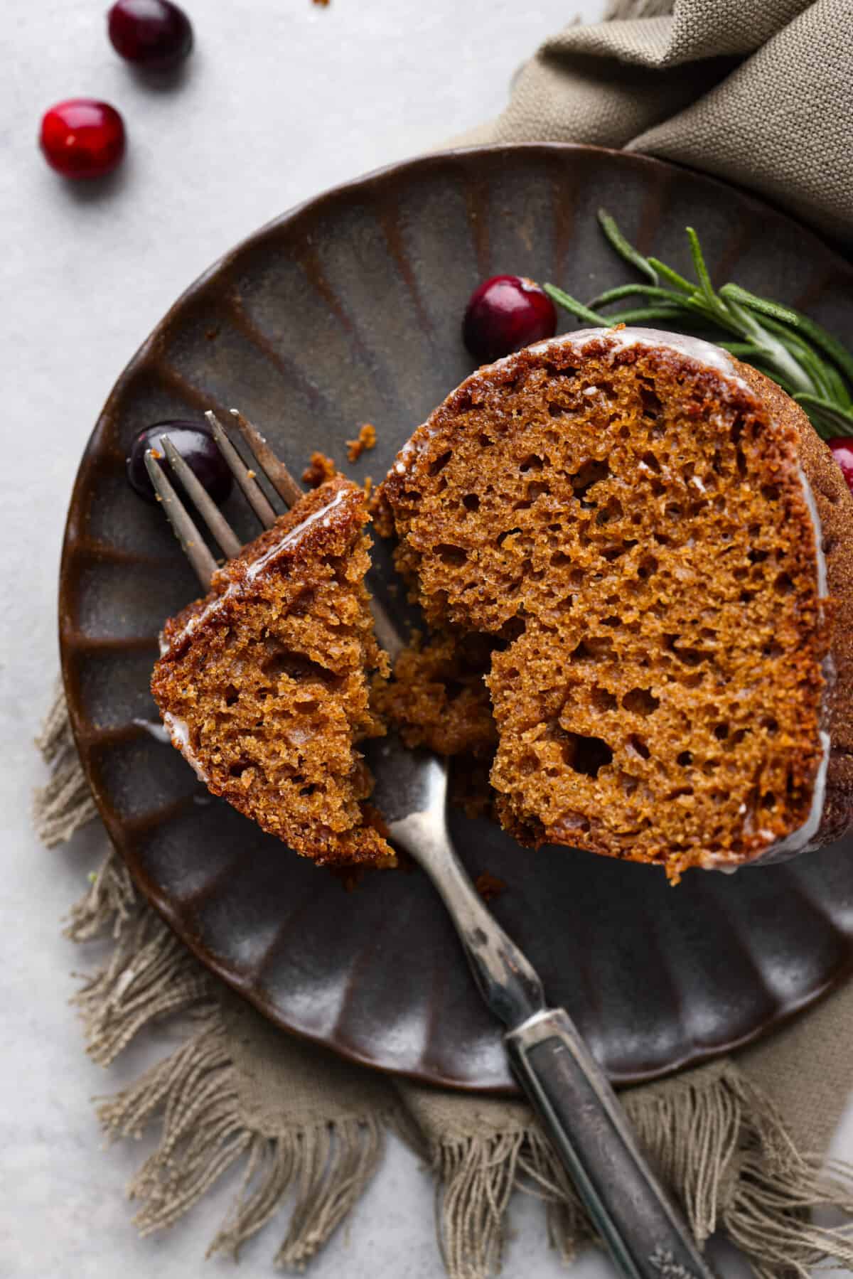 Top-down view of a slice of gingerbread bundt cake on a black scalloped plate.