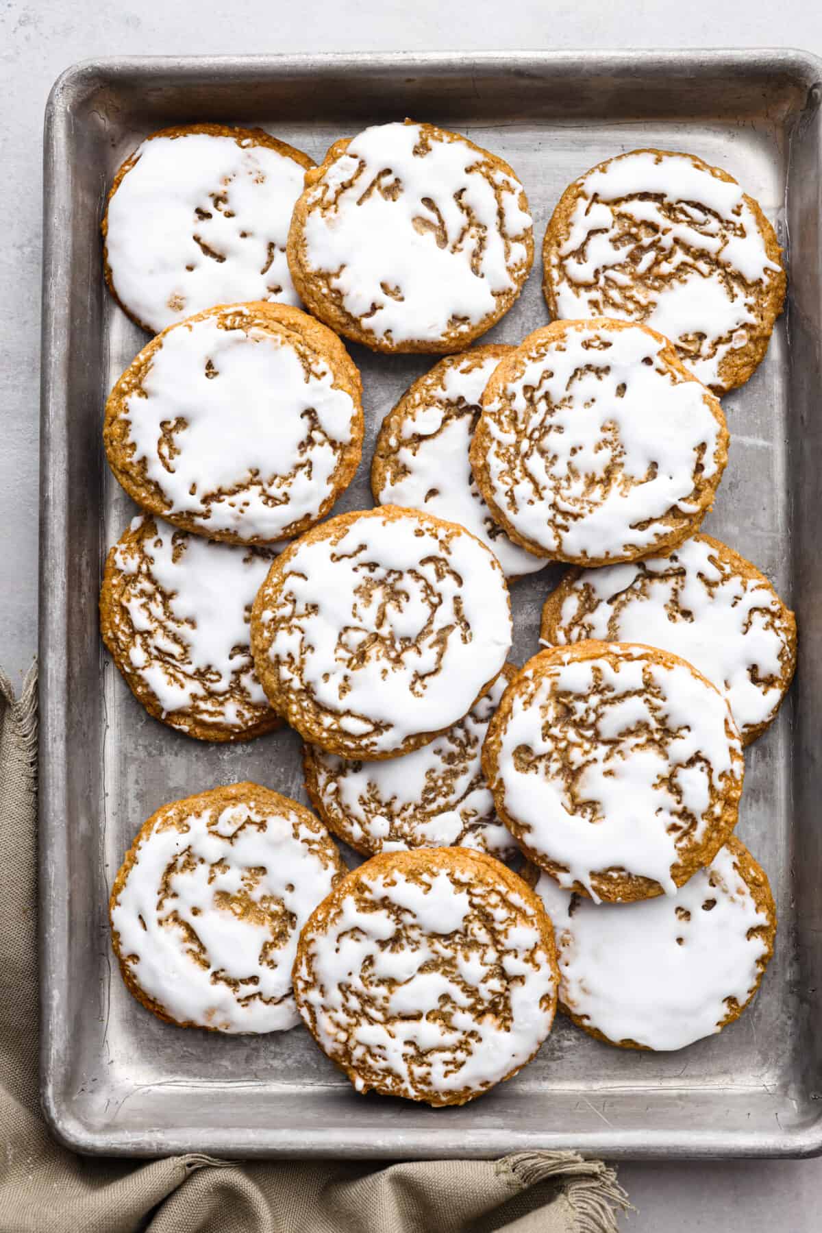 Top-down view of iced oatmeal cookies in a pan.